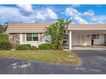 Inviting single-story home featuring a stone accent wall, and a covered carport at 2419 Riverbluff Pkwy # V233, Sarasota, FL 34231