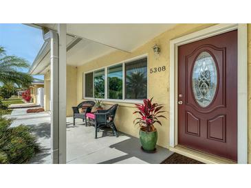 Inviting front porch with comfortable seating and decorative plants, enhancing the home's curb appeal at 5308 39Th W Ave, Bradenton, FL 34209