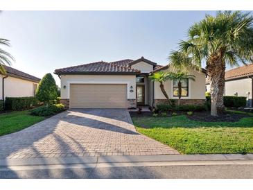 Charming single-story home featuring a tile roof, brick driveway, and lush landscaping at 6560 Willowshire Way, Bradenton, FL 34212
