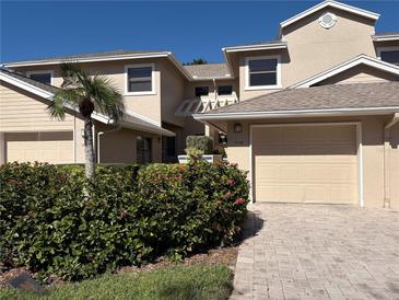 Charming two-story home with a two-car garage, lush landscaping, and a paver driveway at 1718 Starling Dr # 104, Sarasota, FL 34231