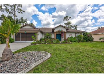 Charming single-story home featuring a well-manicured lawn and beautifully landscaped flowerbeds at 2625 Yuma Ave, North Port, FL 34286