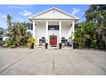 Striking white exterior with columns and double red doors provides an inviting entryway at 3391 Tucson Rd, North Port, FL 34286