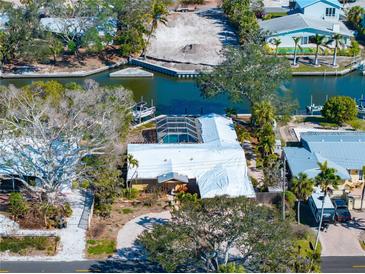 Aerial view of the waterfront home featuring a pool, dock, and a canal view at 5073 Higel Ave, Sarasota, FL 34242