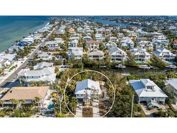 Gorgeous elevated aerial shot showcases this Florida home's location close to the ocean and other homes at 527 Magnolia Ave, Anna Maria, FL 34216