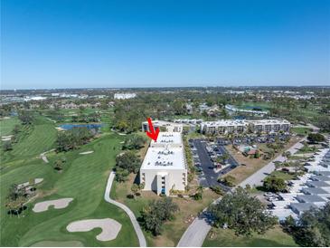 An aerial view of a well-maintained condo building surrounded by lush landscaping and a golf course at 6120 43Rd W St # 103B, Bradenton, FL 34210
