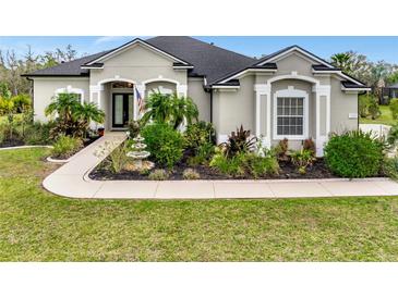 Charming single-story home with a well-manicured lawn, mature landscaping, and a lovely front garden with a small fountain at 7601 226 E St, Bradenton, FL 34211