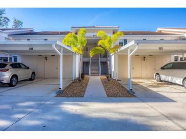 Condo with covered parking, landscaped walkway, and access stairs to the upper units at 801 Montrose Dr # 202, Venice, FL 34293