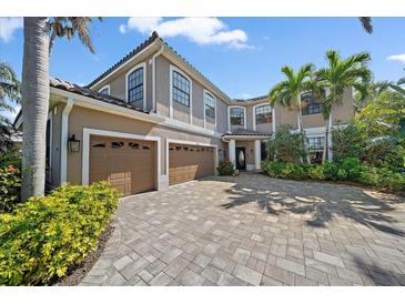 Stunning two-story home featuring a three-car garage, beautiful landscaping, and a brick paved driveway at 820 Placid Lake Dr, Osprey, FL 34229