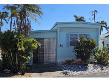 Charming single-story home featuring blue siding, well-maintained landscaping, and a welcoming front entrance at 10315 Cortez W Rd # 28-1, Bradenton, FL 34210