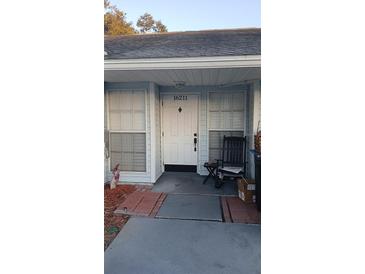 Inviting front entrance with rocking chair and ample natural light from adjacent windows at 16211 Rambling Vine W Dr, Tampa, FL 33624