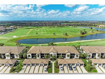 Stunning aerial view of condo buildings overlooking lush golf course with a lake and blue skies at 5710 Palmer Cir # 204, Lakewood Ranch, FL 34211