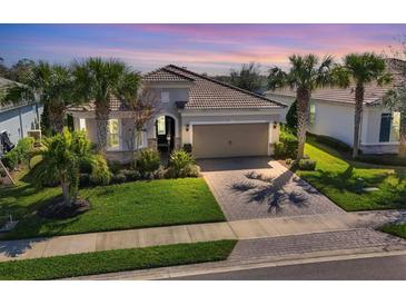 Beautiful single-Gathering home featuring a tile roof, palm trees, and a well-manicured front lawn at 12326 Blue Hill Trl, Bradenton, FL 34211