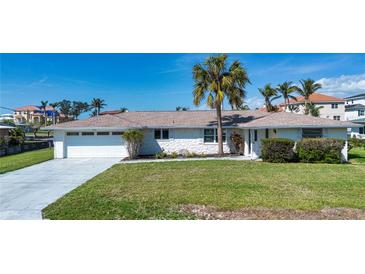 Charming single-story home with a well-manicured lawn and a large palm tree in the front yard at 1541 Shelburne Ln, Sarasota, FL 34231
