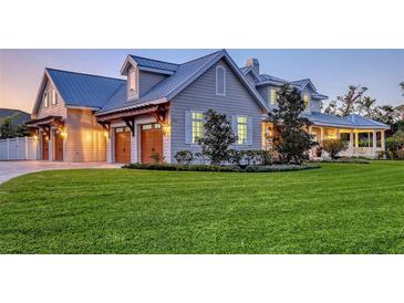 Charming home featuring manicured lawn, attached garages, and beautiful exterior details at 1543 Eastbrook Dr, Sarasota, FL 34231