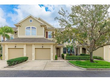 Charming townhouse featuring a tan facade, two-car garage, and manicured landscaping at 8043 St Simons St, Bradenton, FL 34201