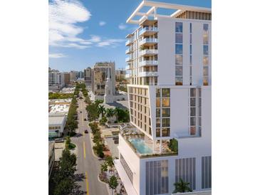 Modern, multi-story building with pool and rooftop deck overlooking the cityscape and bright blue skies at 1703 Main St # 1205, Sarasota, FL 34236