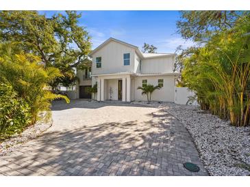 Beautiful white home with modern architecture, a paver driveway and well-maintained landscaping at 3319 S Osprey Ave, Sarasota, FL 34239