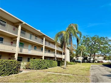 Three-story condo building featuring multiple balconies, manicured lawns, and vibrant green shrubbery at 3987 Maceachen Blvd # 132, Sarasota, FL 34233