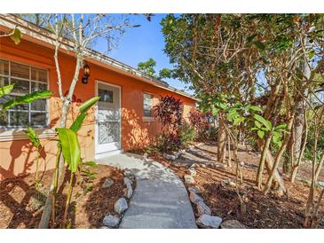 Exterior view of a home showing a landscaped walkway leading to the front door at 4999 Linwood St, Sarasota, FL 34232