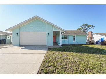 Charming teal home featuring a two-car garage, mature lawn, and a cheerful pink front door at 7807 24Th W Ave, Bradenton, FL 34209