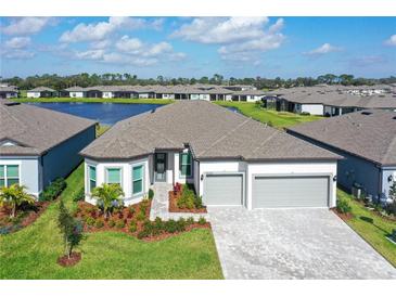 Beautiful single Gathering home with a manicured lawn, paver driveway and a tranquil lake view at 9028 Sunray Cv, Parrish, FL 34219