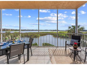 This patio features a dining set and seating with scenic water views and tile flooring at 10520 Boardwalk Loop # 205, Lakewood Ranch, FL 34202