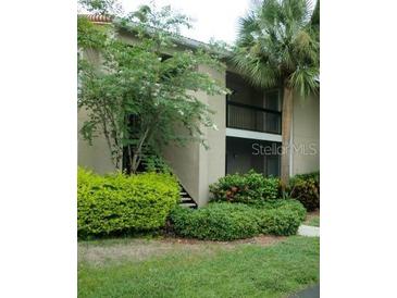 Exterior view of a two-story home featuring lush landscaping and a charming balcony at 4008 Crockers Lake Blvd # 11, Sarasota, FL 34238