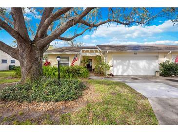 Charming single-story home with a well-manicured lawn, mature trees, and an attached two-car garage at 4050 Oakhurst Dr # 3175, Sarasota, FL 34233
