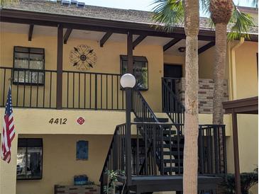 Inviting two-story condo features a painted facade, metal railings, and palm trees at 4412 Spicewood Dr # D, Bradenton, FL 34208