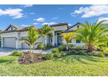 Beautiful single-story home features lush landscaping, well manicured lawn, and a two-car garage at 4813 Sparkling Sea Ln, Lakewood Ranch, FL 34211