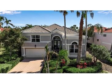 Charming home featuring tropical landscaping, a tile roof, and an attached two-car garage at 3617 Fair Oaks Pl, Longboat Key, FL 34228