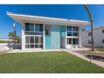 Stunning two-story condo with turquoise accents, large windows, and a lush green lawn at 5400 Gulf Dr # 25, Holmes Beach, FL 34217