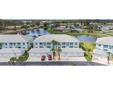 Beautiful condo community with water view and attached garages and palm trees at 5743 Sabal Trace Dr # 101B57, North Port, FL 34287