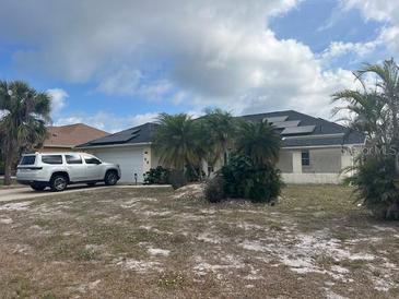 Single story home featuring well maintained lawn, solar panels, and paved driveway at 96 Broadmoor Ln, Rotonda West, FL 33947