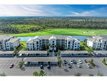 An aerial view of a condo community overlooking a golf course and water feature with covered parking and beautiful landscaping at 18008 Gawthrop Dr # 308, Bradenton, FL 34211