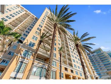 Upscale condo building exterior boasts multiple balconies and inviting tropical palm trees at 750 N Tamiami Trl # 407, Sarasota, FL 34236