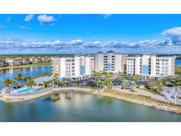 Beautiful aerial view of a lakeside condo community with a swimming pool, manicured landscaping, and ample parking at 10520 Boardwalk Loop # 504, Lakewood Ranch, FL 34202