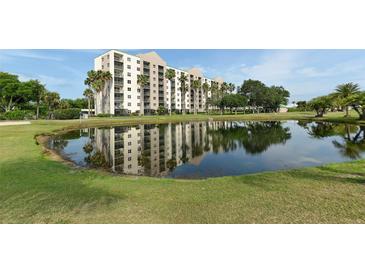 Scenic view of a resort-style building reflected in a pond, surrounded by lush greenery and palm trees at 2320 Terra Ceia Bay Blvd # 808, Palmetto, FL 34221
