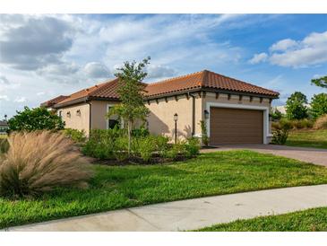 Charming single-story home featuring a well-maintained lawn and a clay tile roof on a sunny day at 3008 Tolmino Ct, Lakewood Ranch, FL 34211