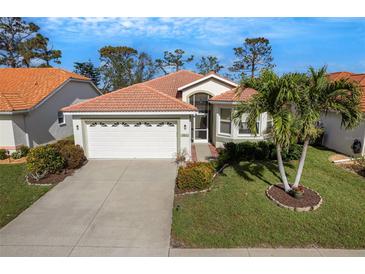 Charming single Gathering home featuring a two-car garage, lush landscaping and a beautiful lawn at 4811 Summertree Rd, Venice, FL 34293