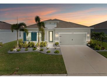 Charming single-story home featuring a well-maintained lawn, fresh landscaping, and a two-car garage at 6306 115Th E Ave, Parrish, FL 34219
