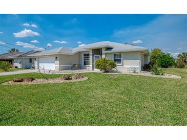 Charming single-story home with a well-manicured lawn and neutral-colored exterior at 3335 Brooklyn Ave, Port Charlotte, FL 33952
