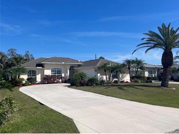 Beautiful single-story home with a well-manicured lawn, mature trees, and a long driveway at 4224 Hall St, Port Charlotte, FL 33948