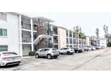 Exterior view of a multi-story condo building with ample parking and convenient stair access to upper units at 5904 Palm Ln # C23, Bradenton, FL 34207