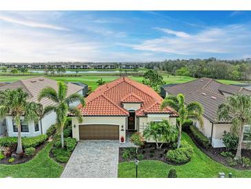 A beautiful one-story home with a tile roof, paved driveway, and lush landscaping on a golf course at 5925 Cessna Run, Bradenton, FL 34211