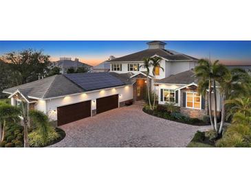 Elegant two-story home showcasing stone accents, lush landscaping, and a paved driveway leading to a two-car garage at 7706 Desoto Memorial Hwy, Bradenton, FL 34209