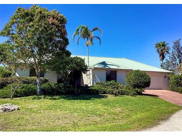 Charming single story home with a green roof, well-manicured lawn and mature landscaping at 1428 Pine Island Ct, Punta Gorda, FL 33950