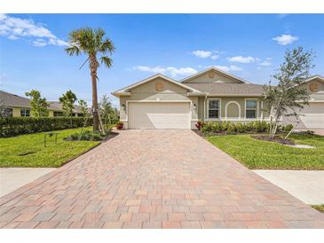 Charming single-story home featuring a brick driveway, palm tree, and manicured lawn at 1524 Remington Trace Dr, Port Charlotte, FL 33953