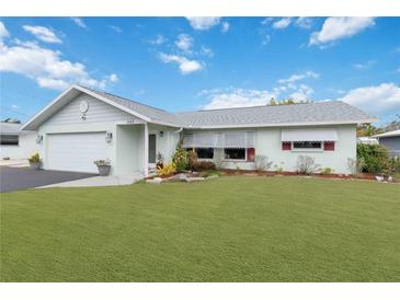 Well-maintained home with a lush green lawn, complemented by crisp, white trim and an attached garage at 1582 Overbrook Rd, Englewood, FL 34223