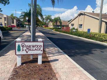 Street view within the Pinewood Village community showcasing well-maintained streets and landscaping at 2763 Woodgate Ln # 208, Sarasota, FL 34231